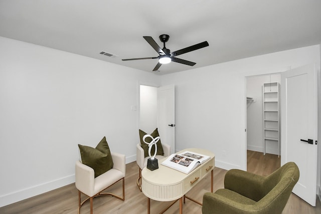 living area with wood-type flooring and ceiling fan