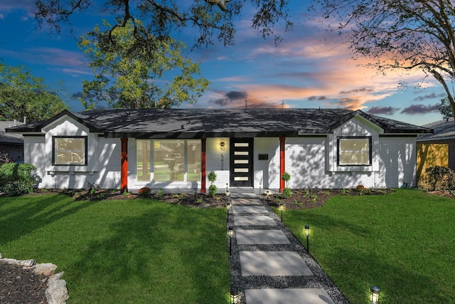 single story home with covered porch and a lawn