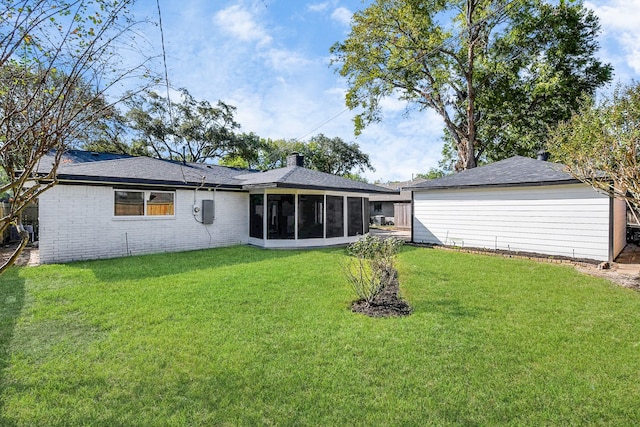 back of property featuring a yard and a sunroom