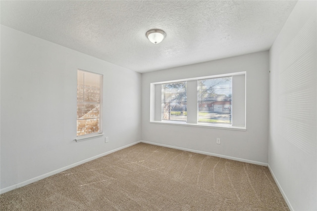 carpeted empty room featuring a textured ceiling