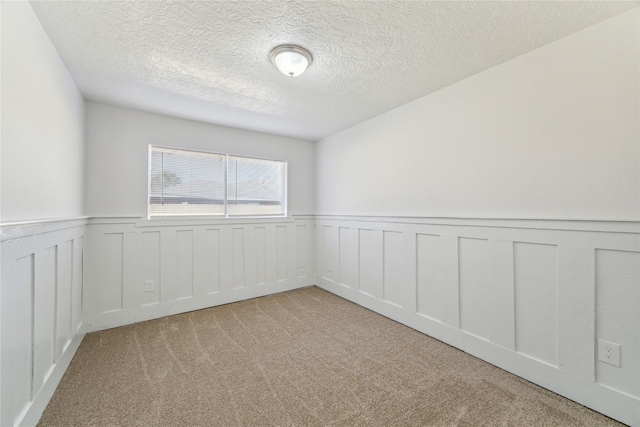 carpeted spare room with a textured ceiling