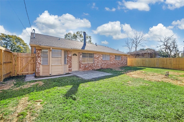 back of property with a yard and a patio