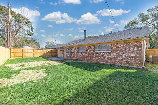 back of property featuring a lawn and central AC unit