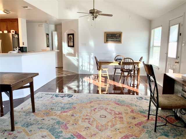 tiled dining room with ceiling fan and vaulted ceiling