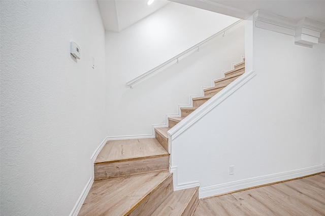 stairs with hardwood / wood-style flooring and ornamental molding