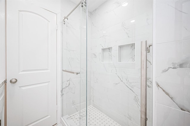 bathroom with a shower with door