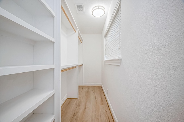 walk in closet with light wood-type flooring