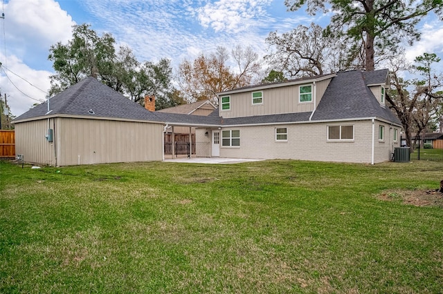 rear view of property featuring a lawn, a patio area, and central AC