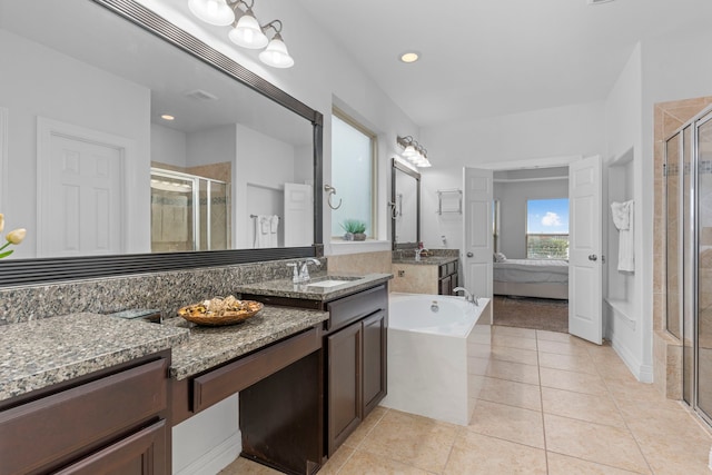 bathroom featuring a stall shower, vanity, a bath, and tile patterned floors