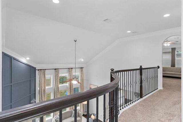 hall with vaulted ceiling, carpet flooring, a wealth of natural light, and crown molding