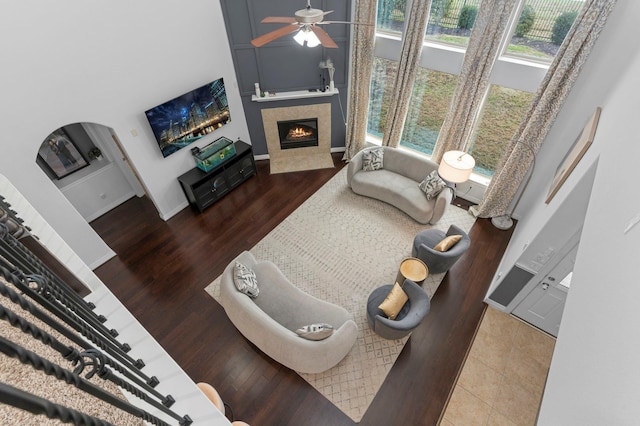 living room featuring wood-type flooring, a fireplace, and ceiling fan