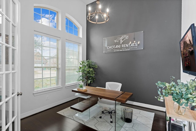 office space featuring a notable chandelier, wood finished floors, and baseboards