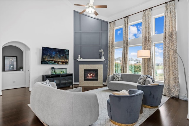 living area featuring high vaulted ceiling, dark wood-type flooring, and a tile fireplace