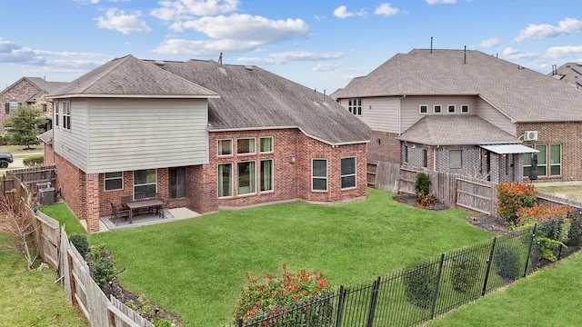 rear view of property with brick siding, a patio, a fenced backyard, and a lawn