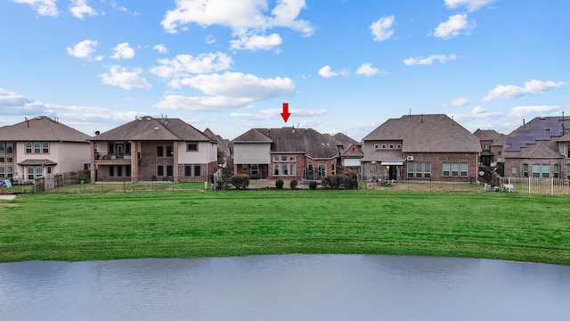 view of property's community with a lawn and a water view