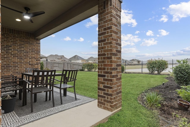 view of yard featuring ceiling fan, a patio, outdoor dining area, and a fenced backyard