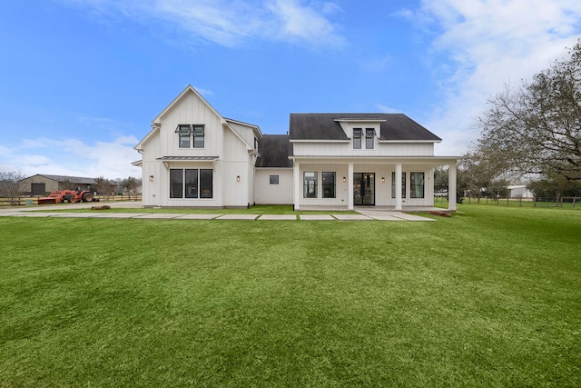 rear view of property with a yard and covered porch