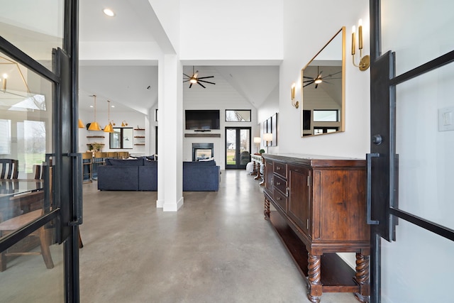 corridor with high vaulted ceiling and concrete flooring