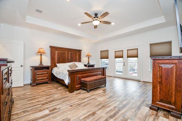 bedroom with a raised ceiling, access to outside, ceiling fan, and french doors