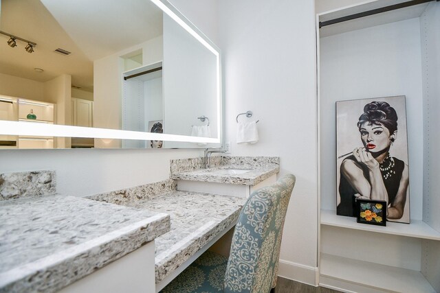 bathroom with hardwood / wood-style flooring, vanity, and lofted ceiling