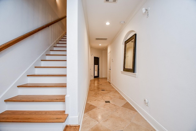 stairs featuring crown molding