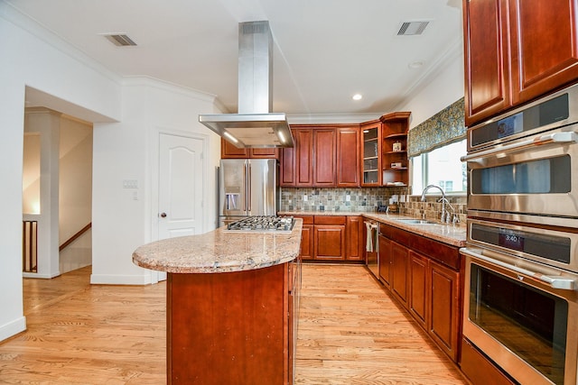 kitchen with island range hood, a center island, stainless steel appliances, light stone countertops, and backsplash