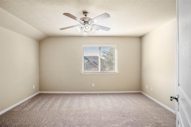 carpeted empty room featuring a textured ceiling, ceiling fan, and vaulted ceiling