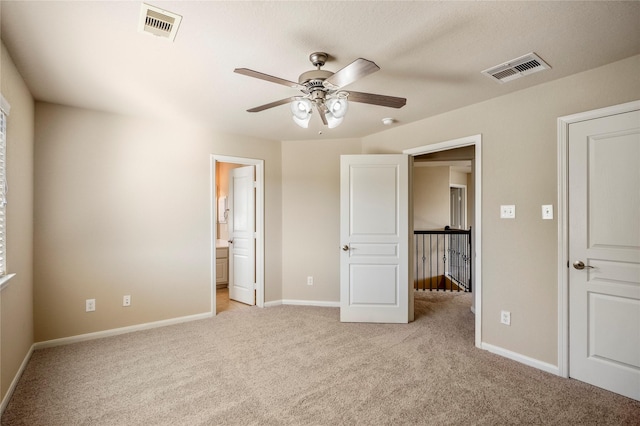 unfurnished bedroom with ensuite bathroom, ceiling fan, and light colored carpet