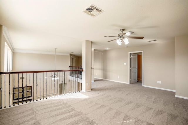 carpeted empty room with ceiling fan and crown molding