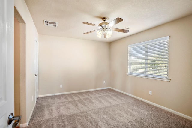 spare room featuring light carpet and ceiling fan