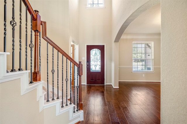 foyer entrance with ornamental molding and dark hardwood / wood-style flooring