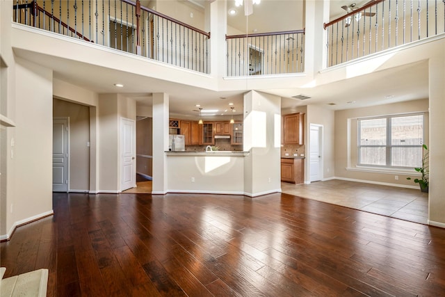 unfurnished living room with a high ceiling and hardwood / wood-style floors