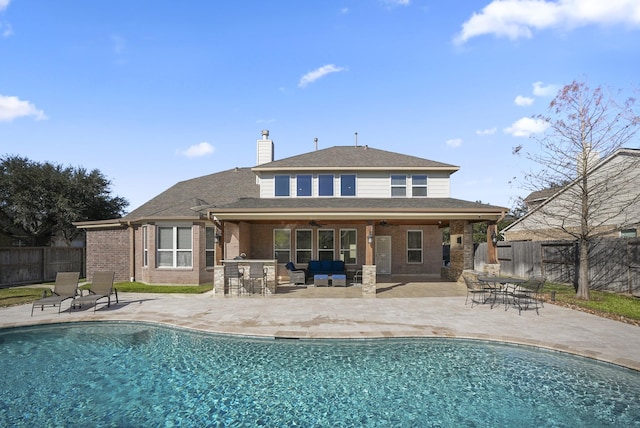 back of property featuring ceiling fan, a fenced in pool, and a patio area