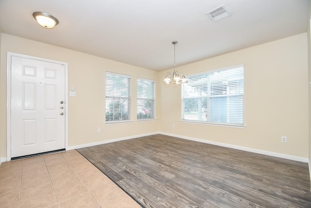 entrance foyer with light hardwood / wood-style floors and an inviting chandelier