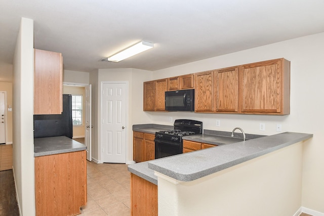 kitchen featuring black appliances, light tile patterned flooring, and kitchen peninsula