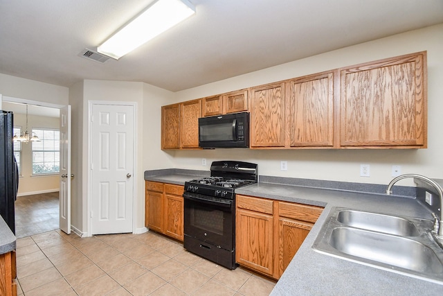 kitchen featuring a chandelier, light tile patterned floors, sink, and black appliances