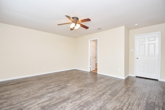 spare room with dark hardwood / wood-style flooring and ceiling fan