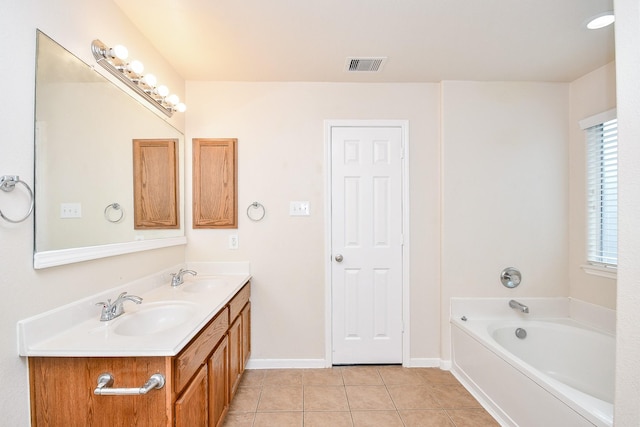 bathroom with tile patterned floors, a bathtub, and vanity