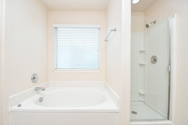 bathroom featuring independent shower and bath