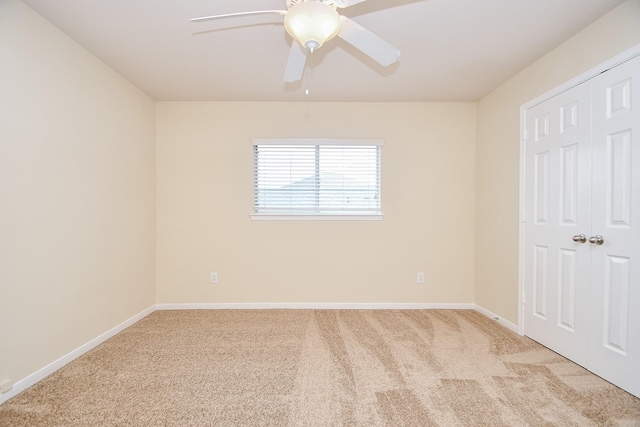 empty room with light colored carpet and ceiling fan