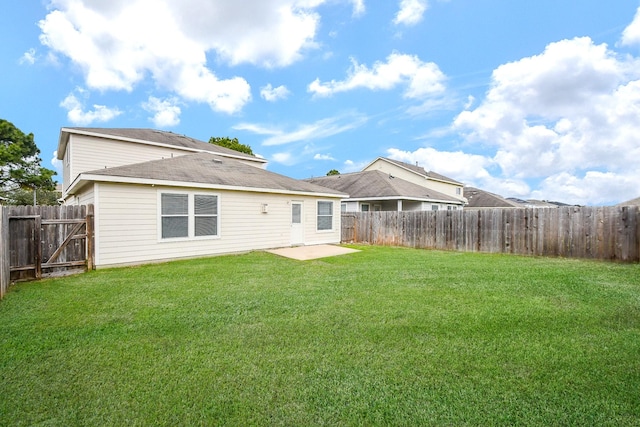 back of house featuring a patio area and a yard