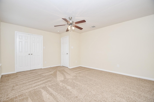 unfurnished bedroom with ceiling fan, a closet, and carpet