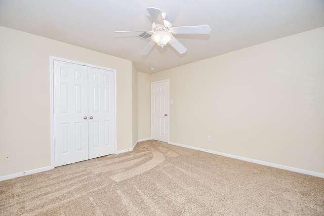 unfurnished bedroom featuring carpet floors, a closet, and ceiling fan