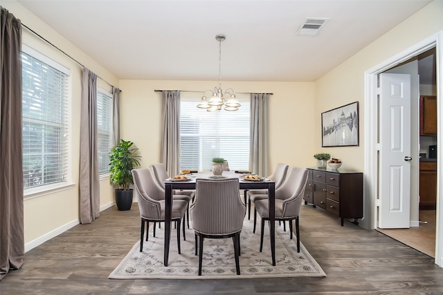 dining room featuring dark hardwood / wood-style floors and an inviting chandelier