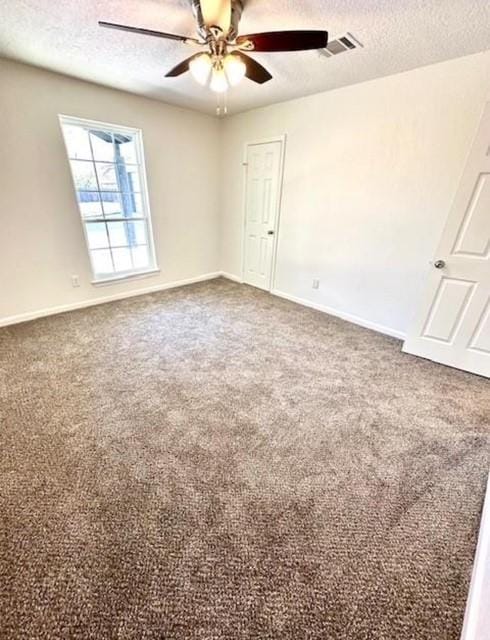 carpeted spare room with ceiling fan and a textured ceiling