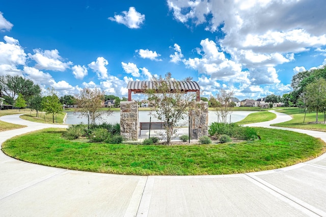 view of community with a water view and a lawn