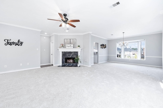 unfurnished living room featuring ceiling fan with notable chandelier, light colored carpet, ornamental molding, and a premium fireplace