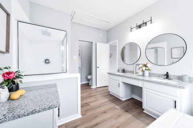 bathroom with wood-type flooring, vanity, and toilet