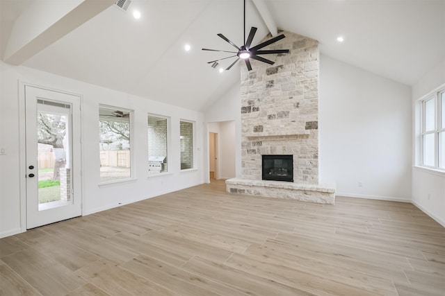 unfurnished living room featuring a fireplace, beam ceiling, high vaulted ceiling, and ceiling fan