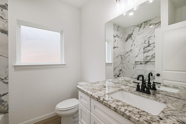 bathroom with a shower, vanity, wood-type flooring, and toilet